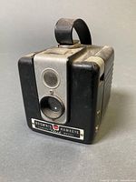 Front angled view showing lens, viewfinder and nameplate