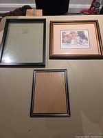 Three frames: empty 11x14 black frame, framed Simandle print, empty 8x10 black frame