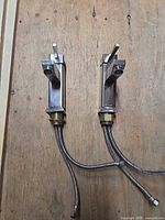 Two matching brushed nickel single-lever faucets side by side showing overall design and attached supply hoses