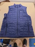 Front view of blue Bench bubble vest showing pockets and zipper
