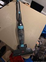 Full view of Bissell stick vacuum showing cord, handle, dust cup and floor head