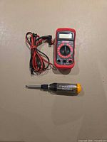Multimeter with leads and multi-bit screwdriver shown together