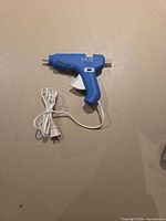 Front view of blue dual temp hot glue gun with cord