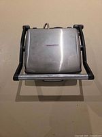 Closed view showing stainless lid with logo and overall appliance