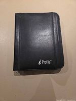 Front view of closed black leather portfolio showing iProfile logo