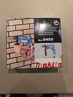 Front of retail box showing Makita 8450 percussion drill image and branding