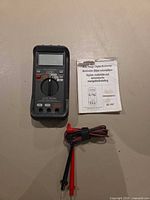 Front view of Micronta multimeter with manual and test leads