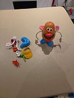 Assembled Mr. Potato Head standing with accessories laid out beside