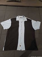 Front view of Nat Nast short-sleeve shirt showing sail/black color blocks and buttons