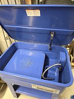 Open lid view showing interior tray, pump spout and basket