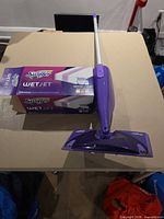 Swiffer WetJet mop with opened box of WetJet pads