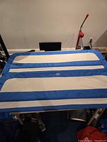 Two blue and white bed rails laid flat on table