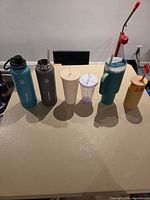 Six drinkware pieces lined up on table