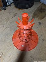Full view of orange plastic bottle tree rack showing tiers and central column
