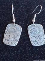 full view of both earrings on black background
