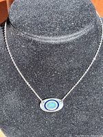 Front view of necklace on display bust showing pendant design and chain