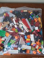 Front view of sealed bag containing assorted multicolor LEGO bricks and parts