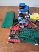 Assorted bricks showing green roof panel, wheeled trailer base, wheels, blue truck cab parts