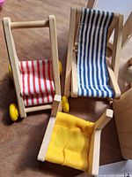 Close view of three chairs: blue striped, red striped, yellow fabric