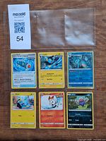 All six Pokémon cards in binder sleeve with lot tag