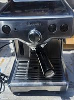 Front view showing Breville logo, control dial, buttons, attached portafilter and drip tray
