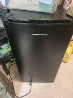 Front view of closed black Hamilton Beach mini fridge