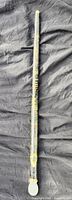 Full length view of painted stick on black cloth