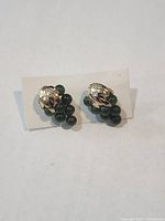 Front view of both earrings showing gold-tone leaves and green bead clusters
