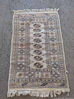 Full view of entire 2' x 4' Bokhara rug showing overall design and fringe