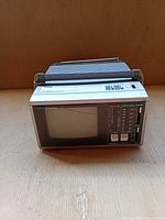 Front view showing CRT screen, tuner dials, function buttons