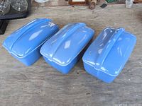 Three blue Hall China covered dishes side by side