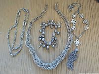 All five silver-plated jewellery items arranged on surface