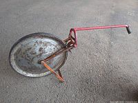 Side view of Rolatape measuring wheel showing full wheel, handle, and stand