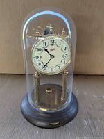 Front view of Schatz torsion clock under glass dome