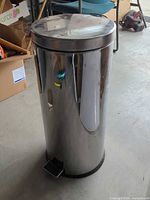 Full view of cylindrical stainless steel trash can with foot pedal