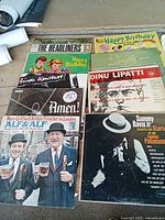 Overall view of eight album covers on tabletop including Headliners ’63, two Happy Birthday records, Dinu Lipatti, etc.
