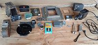 Assorted projector parts, camera, lenses, hardware laid out