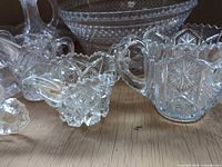 Group view showing sugar bowl, small ruffled bowl, part of creamer and vases with large serving bowl in background