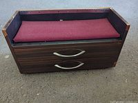 Front view showing two drawers, metal handles, burgundy fabric top