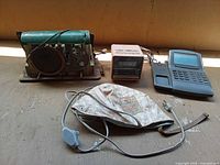 Group shot of all items: radio chassis, clock radio, telephone base, Wella hair cap and cords