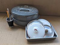 Group shot of roaster, baking tray, enamel lids, utensil cup
