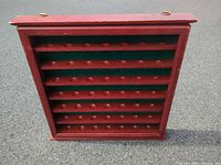 Front view of red wooden display case showing shelves and felt backing