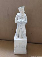 Front view of plaster sailor figurine on inscribed base