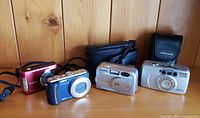 Group shot of four cameras and two cases on shelf