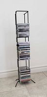 full view of black wrought iron CD tower filled with CDs