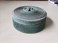 Box with lid on showing textured green exterior and spiral lid design