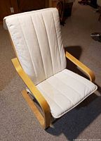 Front view of Ikea Poang armchair showing white cushion and bentwood frame