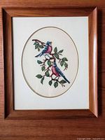 Front view of framed petitpoint showing birds and frame