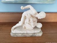 Front view of alabaster wrestlers statue on marble base