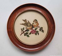 Front view showing embroidered design within round wood frame